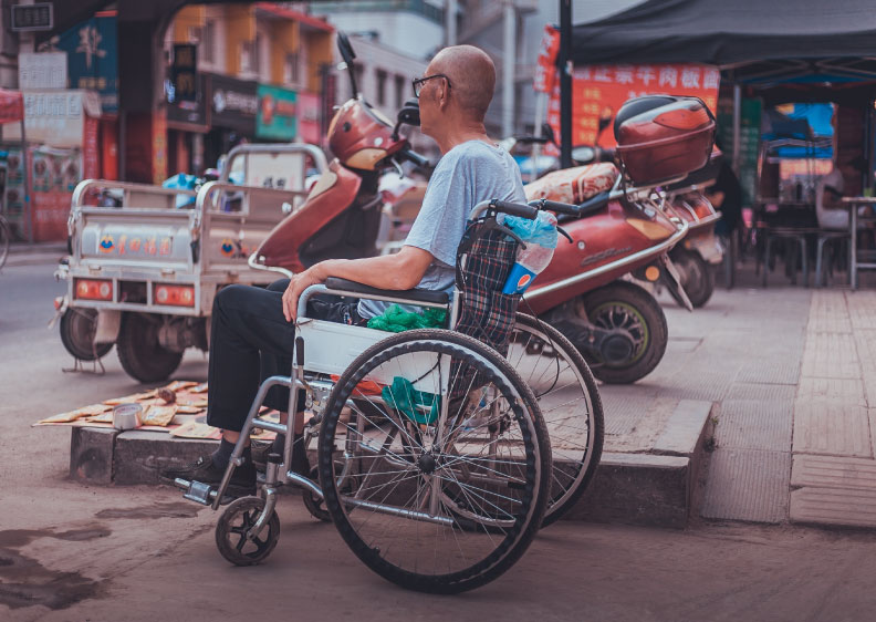 Man in wheelchair waiting to cross the street