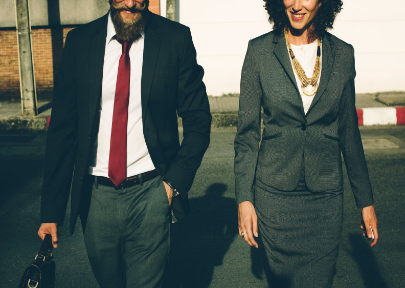 Man and woman in business outfits walking and having a discussion