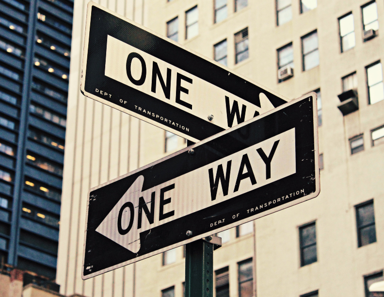 Two perpendicular one way street signs.