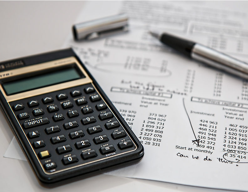 A calculator and pen resting on a financial document